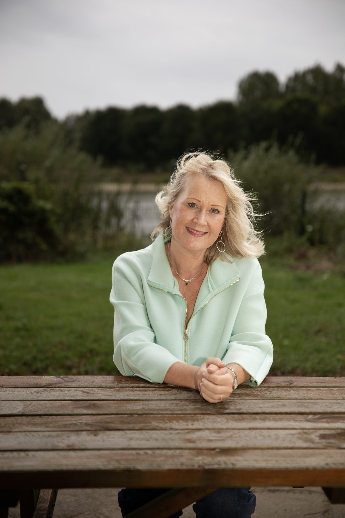 Portret van Martine Bernart aan een picknicktafel bij het water